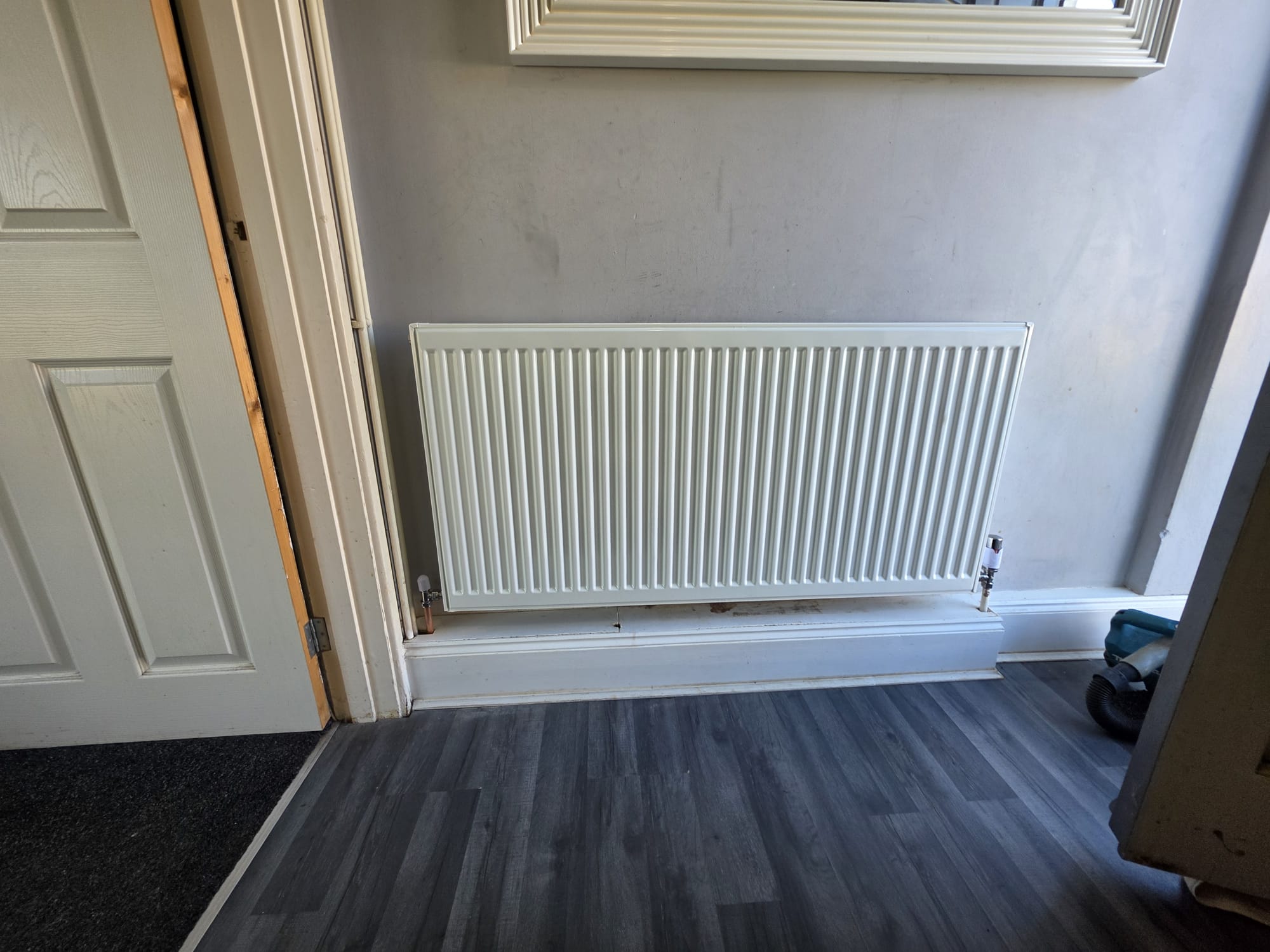 New white double-panel radiator installed in hallway with TRV, Surrey