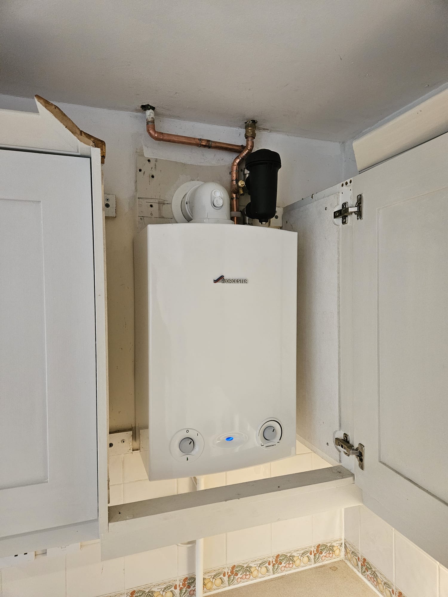Worcester Greenstar combi boiler installed in a kitchen wall cupboard with MagnaClean filter, Surrey