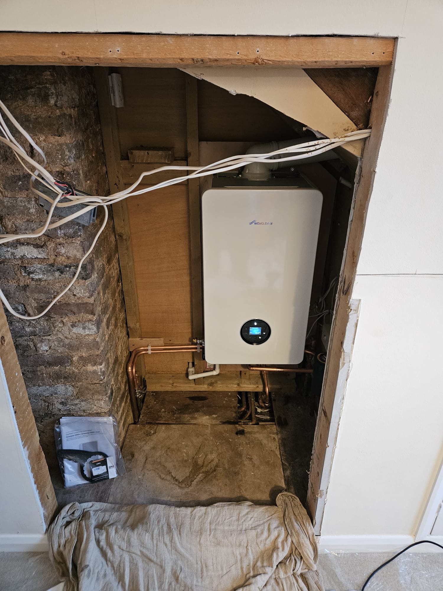 Worcester Greenstar combi boiler in stripped-back wall recess, Surrey